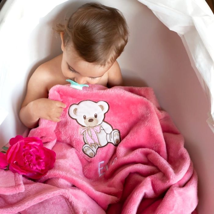 Klein meisje met haar gepersonaliseerde roze dekentje