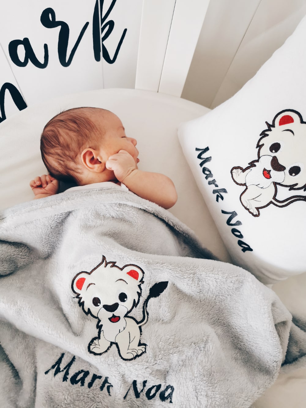 Schattige babyjongen rust vredig op zijn bed, knus met een zachte en gezellige gepersonaliseerde kussen en deken, aangepast met zijn naam en een charmant ontwerp.