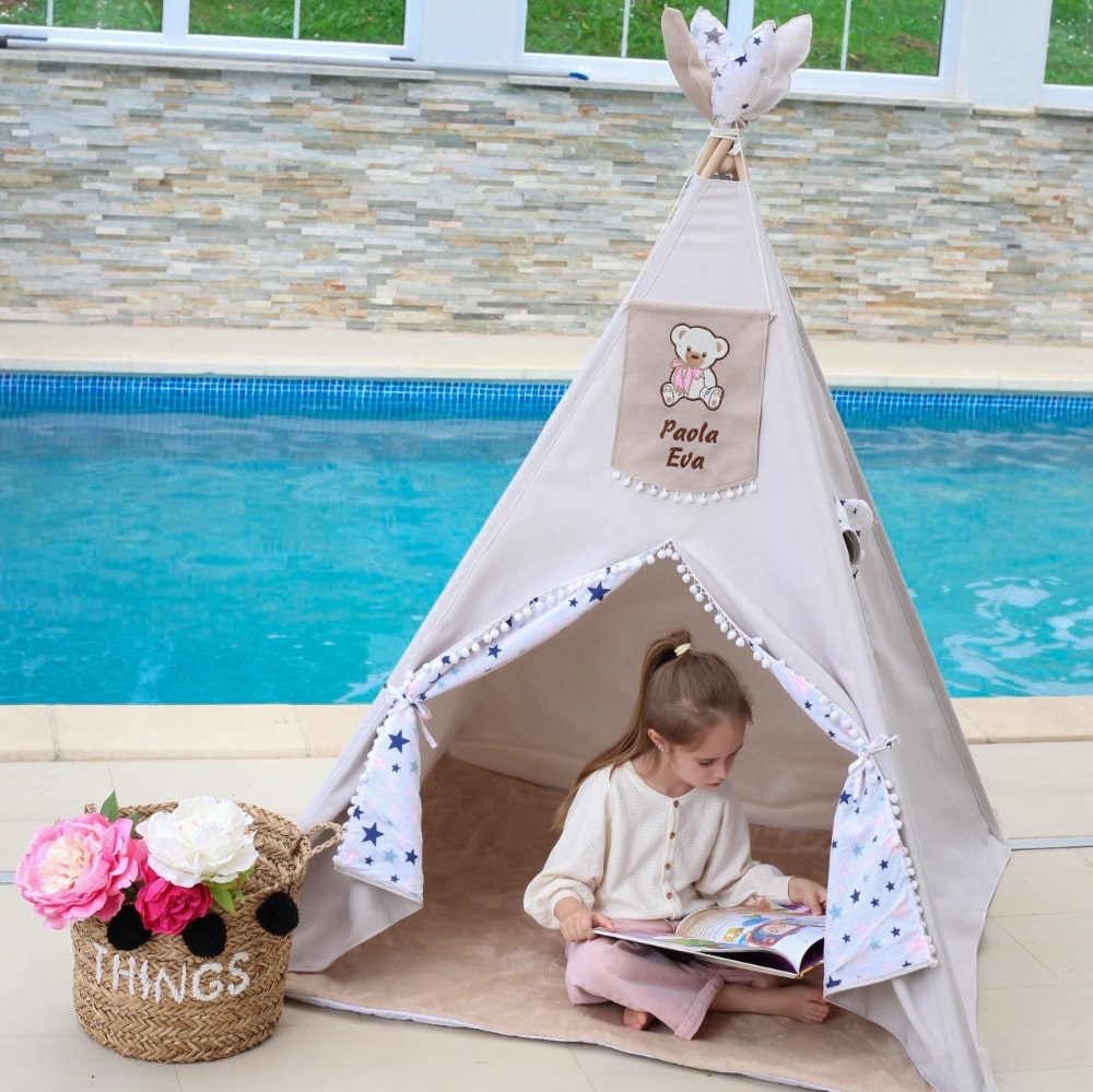 Girl kid reading a book in her personalized teepee tent